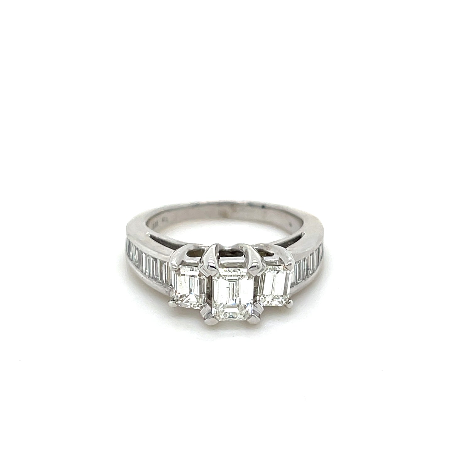0.63 CT Emerald Center with two 0.62 CT Emerald side stones & 0.58 CT Baguettes mounted in a 14 KT White Gold Engagement Ring.